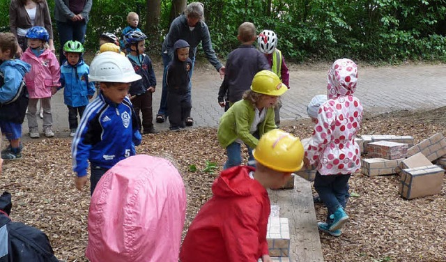 Die Kinder des Kindergartens St. Laure...symbolisch die  renovierte Mauer nach.  | Foto: Christine  weirich