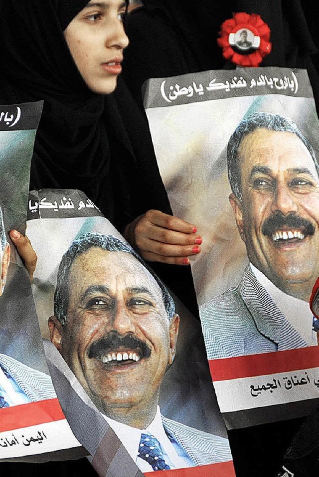 Eine Anhngerin Salehs mit Fotos des Prsidenten  | Foto: dpa