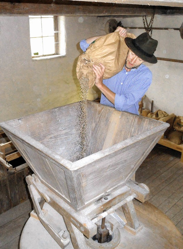 Auf dem Programm des Mühlen- und Käsef...s Herr Getreide in den Mühlentrichter. | Foto: Josef Faller Auf dem Programm des Mühlen- und Käsef...s Herr Getreide in den Mühlentrichter. | Foto: Josef Faller