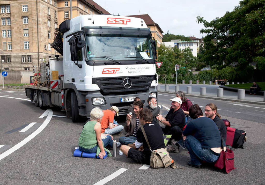 Stuttgart 21-Gegner blockieren einen LKW mit Baumaterialien.
