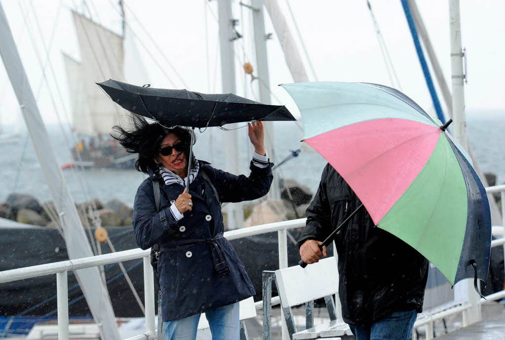 Regen und starker Wind machen den Besuchern der Segelwettbewerbe im Kieler Olympiahafen zu schaffen.