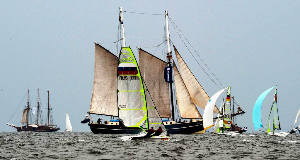Ein Gaffelschoner (M) trifft auf Boote der 49er Klasse bei einer Wettfahrt der Kieler Woche.