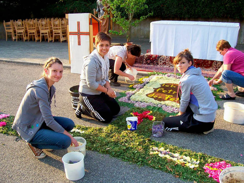 Auch die Firmlinge halfen beim Legen der Blumenteppiche.