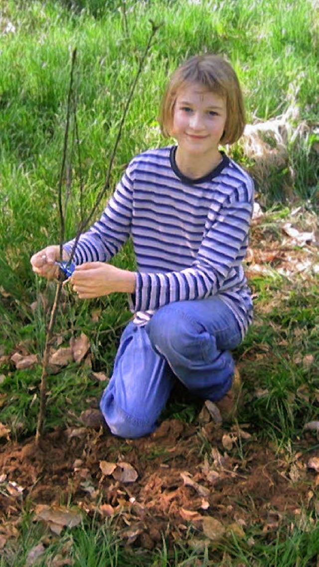 Helen pflanzt einen kleinen Baum im Wald.   | Foto: Privat