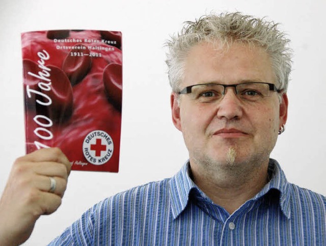 Bereitschaftsfhrer Stefan Ohm mit der...tragenen Festschrift zum DRK-Jubilum   | Foto: FREY