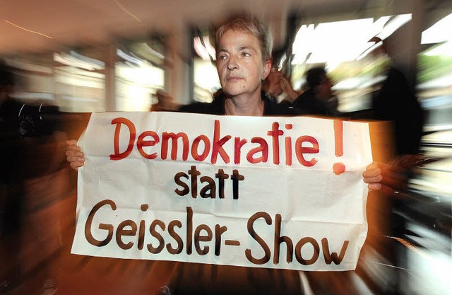 Eine Bahnhofsgegnerin protestiert am F...schend einen eigenen Bahnhofsplan vor.  | Foto: seeger/dpa