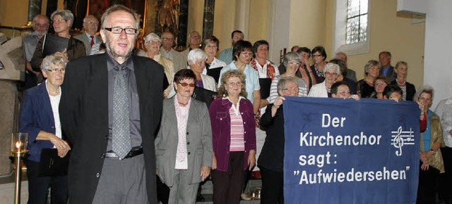 Der scheidende Dirigent Klaus Himmelsbach mit seinem Chor im Hintergrund  | Foto: Heidi Fssel