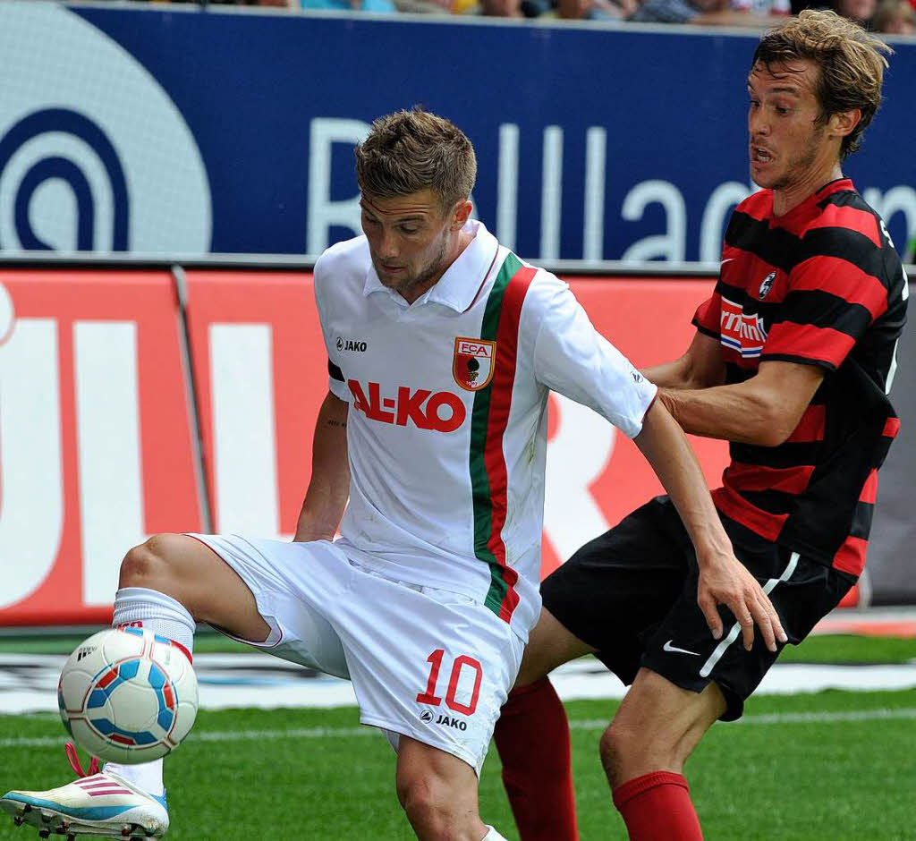 Daniel Baier versucht, den Ball gegen Freiburgs Julian Schuster (r.) zu behaupten.