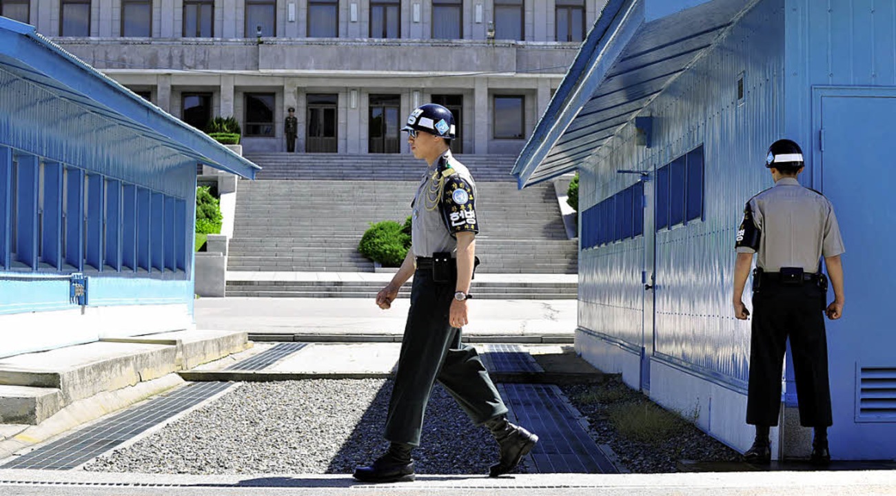Die Grenze zwischen Sd (vorne) und No...verluft mitten durch die Holzhuser.   | Foto: FOTOS: DPA/AFP