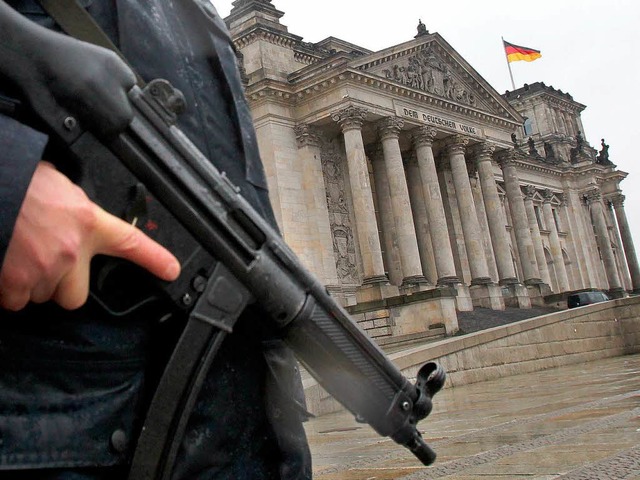 Zum Schutz vor Angriffen steht ein Polizist vor dem Reichstag in Berlin.   | Foto: dpa