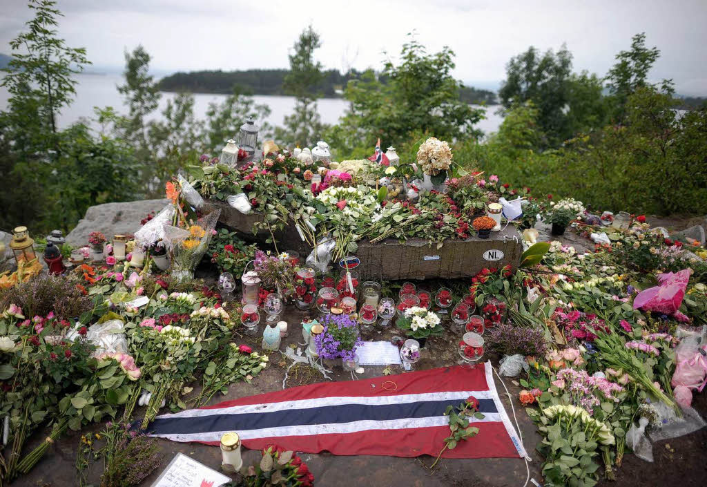 Blumen, Flaggen und Kerzen stehen im Gedenken an die Opfer  gegenber der Fjordinsel Utoya in Norwegen.