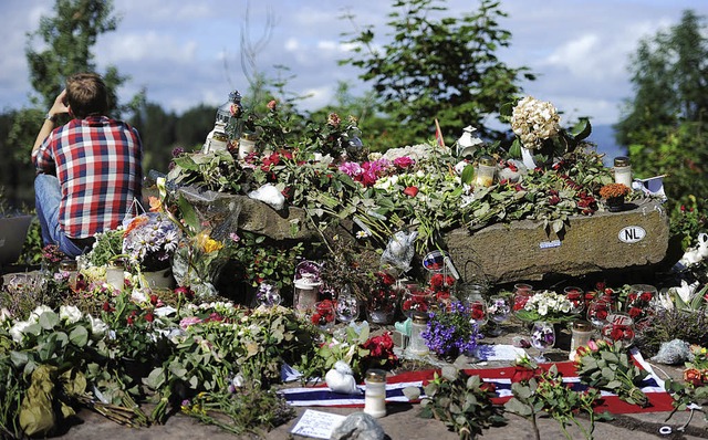 Ein Mann sitzt am Samstag an einer Ste...e Opfer des Terroranschlags erinnern.   | Foto: dpa