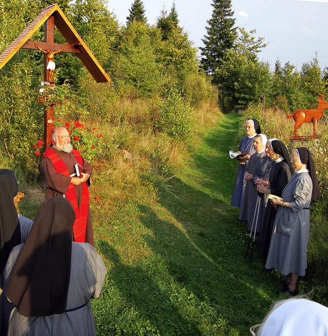 Kapuzinerpater Norbert Schlenker weiht das neue Kreuz im Abendsonnenlicht.   | Foto: Manfred-G. Haderer