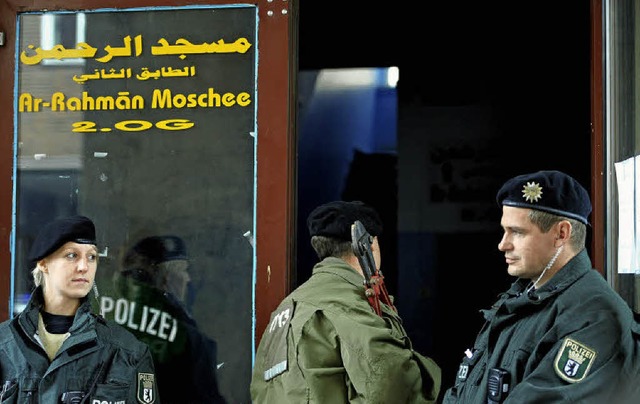 Ein Polizist geht mit einem Bolzenschn...e Al-Rahman-Moschee in Berlin-Wedding.  | Foto: dapd