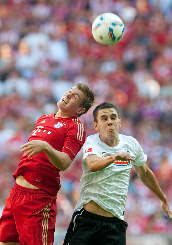 Toni Kroos und der F reiburger Johannes Flum im Zweikampf um den Ball.