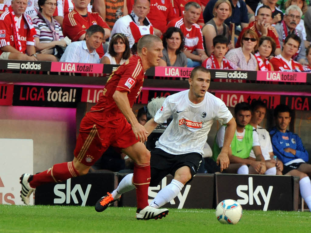 Bastian Schweinsteiger (FC Bayern Mnchen) und Erik Jendrisek (SC Freiburg) eilen dem Ball hinterher.