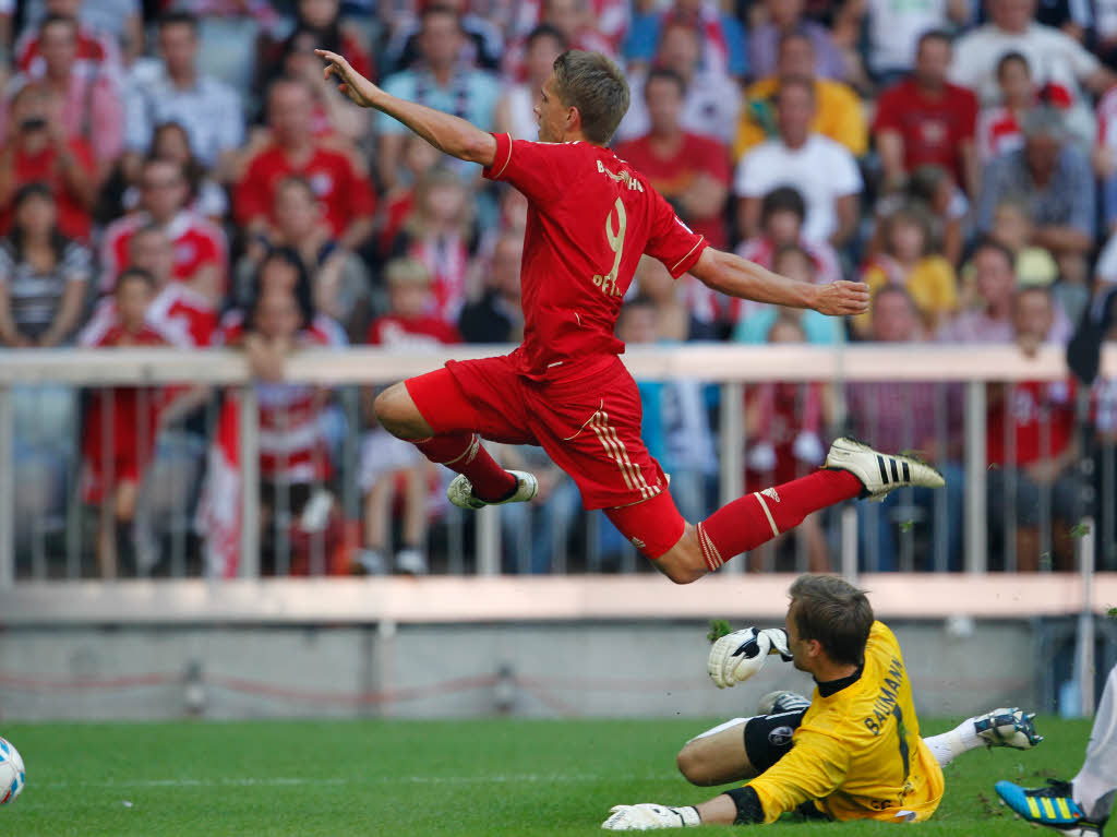 Spektakulre Aktion im Kampf um den Ball. Nils Petersen (FC Bayern Mnchen) und der Freiburger Keeper Oliver Baumann.