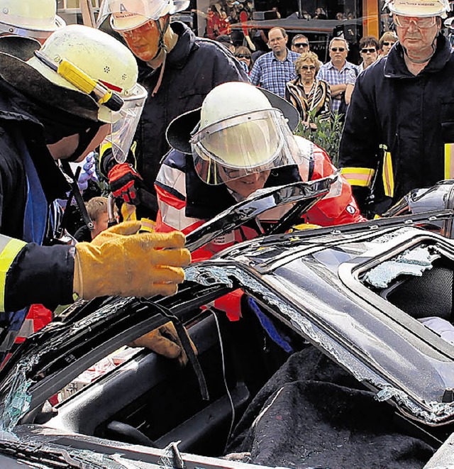 Ein Verletzter wird aus einem Auto befreit.   | Foto: LBECK