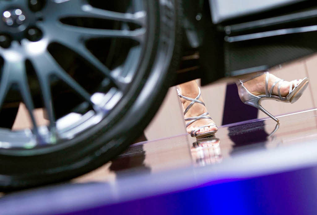 Eine Messe-Hostesse steht am Stand von Infiniti hinter einem Infiniti FX in der sportlichen "Sebastian Vettel-Version".