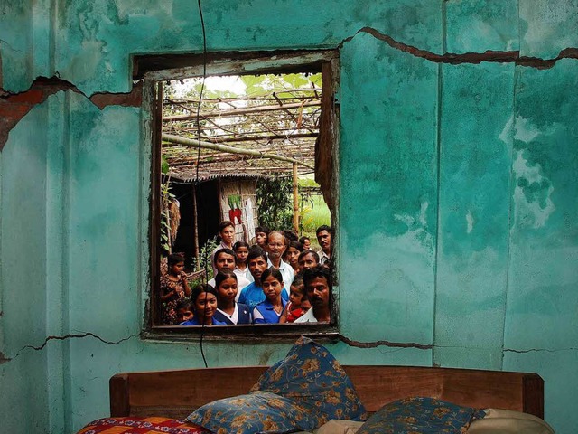 Dorfbewohner begutachten die Risse in einem Haus im indischen Jalpaiguri.   | Foto: dpa