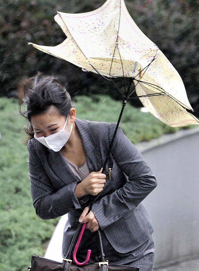 Schirme festhalten war in Tokio angesa...e frher nach Hause geschickt wurden.   | Foto: AFP