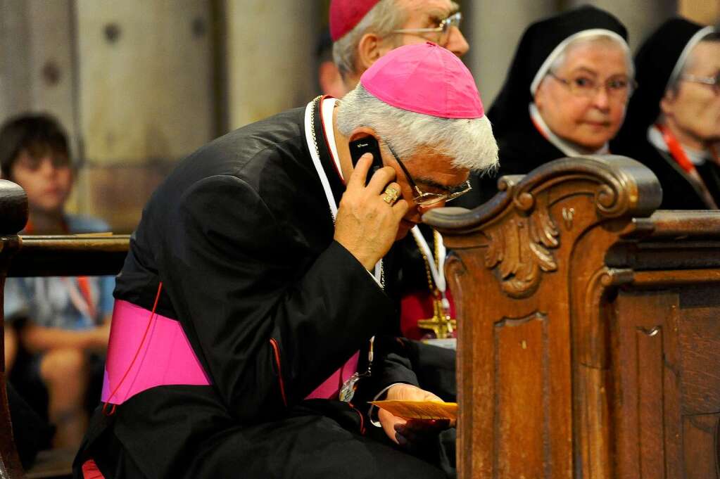 Ein Geistlicher telefoniert mit seinem Handy im Mnster.