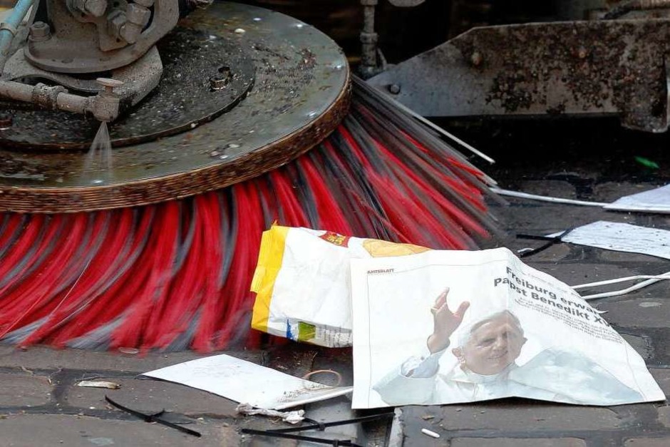 Eine Kehrmaschine beseitigt eine Zeitung mit dem Konterfei des Papsts. (Foto: dapd) Eine Kehrmaschine beseitigt eine Zeitung mit dem Konterfei des Papsts. (Foto: dapd)