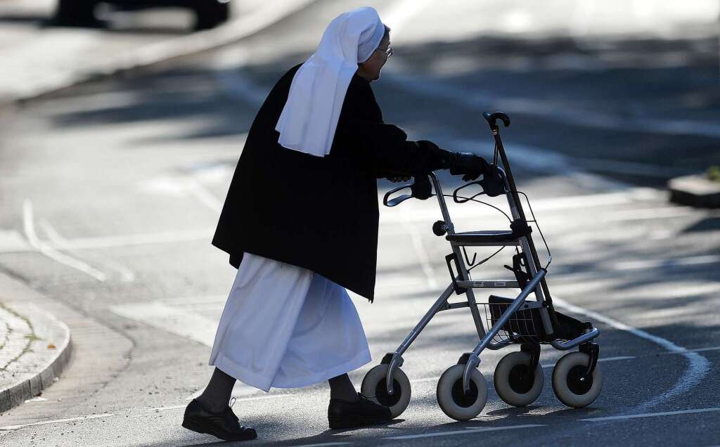 Eine Nonne macht sich mit einem Rollator auf den Weg zum Papst.