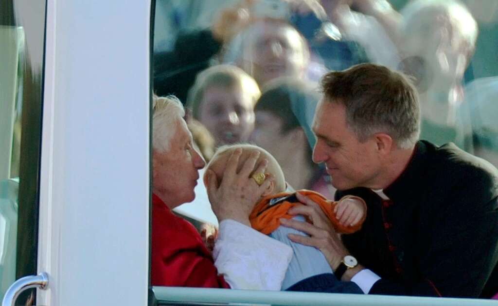 Im Papamobil segnet der Papst ein Baby. Rechts: Georg Gnswein, Privatsekretr des Papsts.