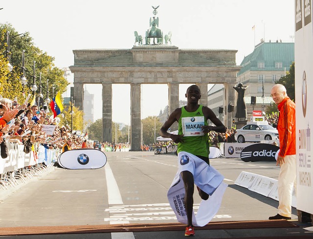 Patrick Makau berquert die Ziellinie beim Brandenburger Tor in Berlin.  | Foto: dapd