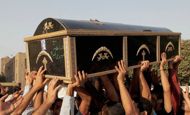 gyptische Kopten tragen den Sarg eines Opfers durch die Straen Kairos.  | Foto: AFP