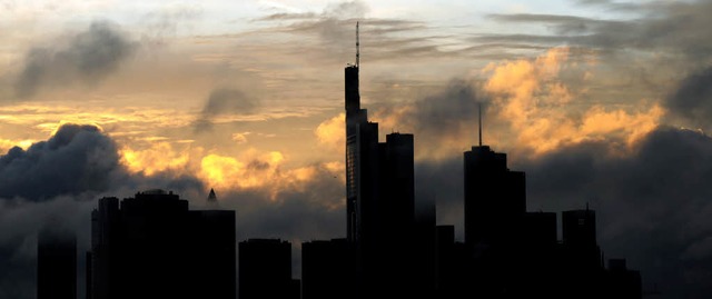 Regenwolken ziehen bei Sonnenuntergang ber den Bankentrmen von Frankfurt auf.   | Foto: dpa