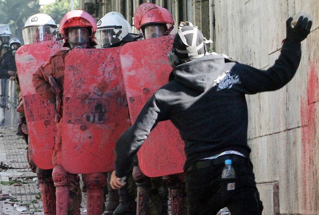 Ein Randalierer wirft einen Stein gege...die meisten protestierten friedlich.    | Foto: dpa