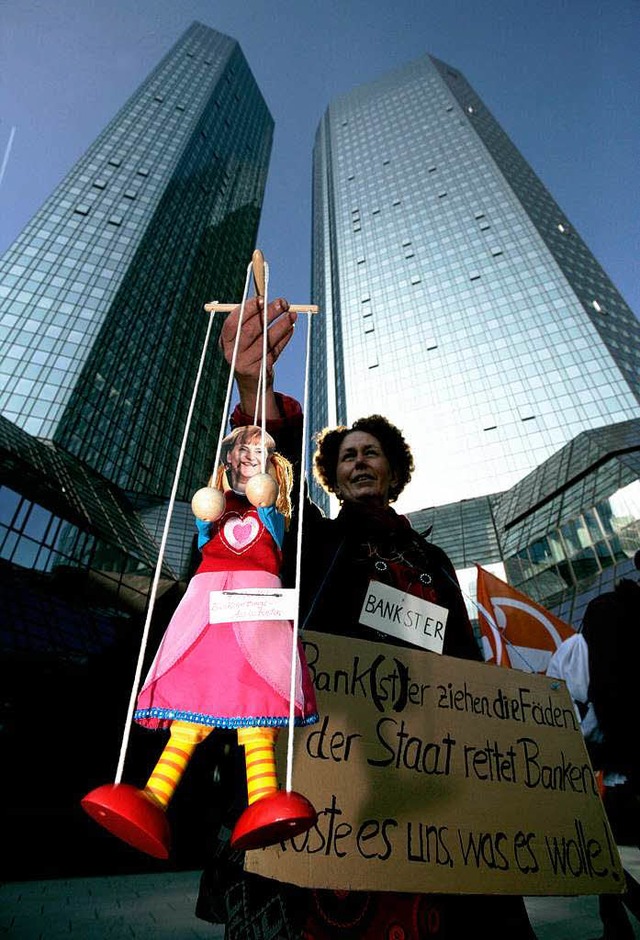 Eine Demonstrantin der Bewegung &#8222... der Deutschen Bank mit Merkel-Puppe    | Foto: dapd