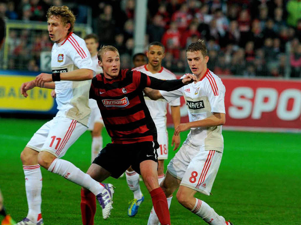 Felix Bastians (SC Freiburg) wird von den Leverkusenern Kieling und Bender in die Zange genommen.