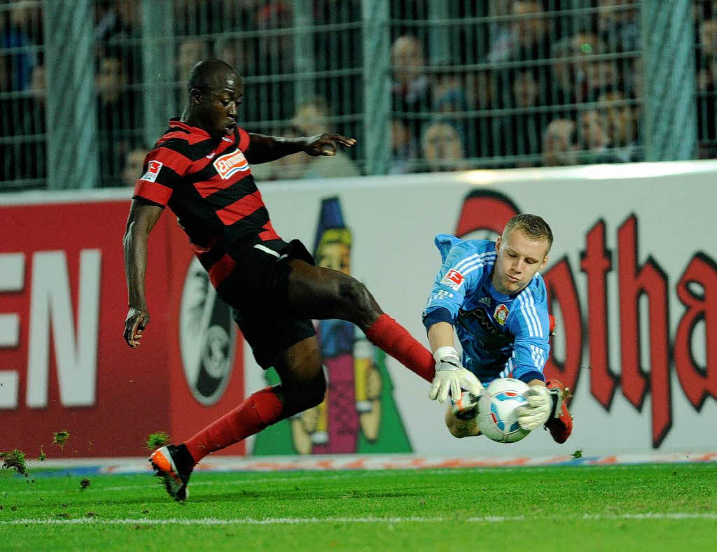 Bernd Leno von Leverkusen fngt den Ball vor Garra Dembele (l) von Freiburg.