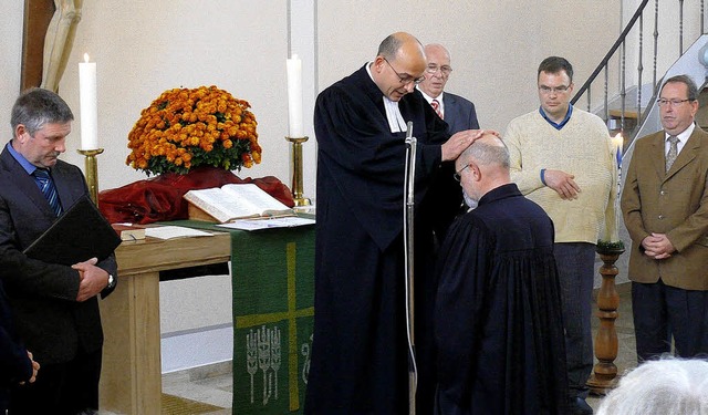Dekan Rainer Becker segnet  Pfarrer Ba...surkunde des Landesbischofs erhalten.   | Foto: alfred arbandt