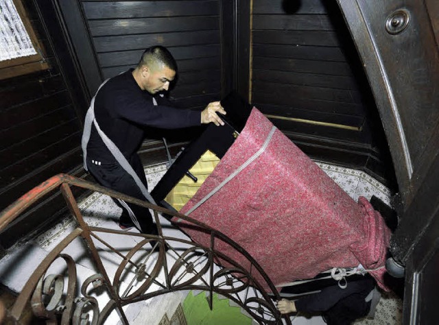 Pavel Barkoci und sein Kollege zirkeln das Klavier durch das enge Treppenhaus.   | Foto: ingo schneider