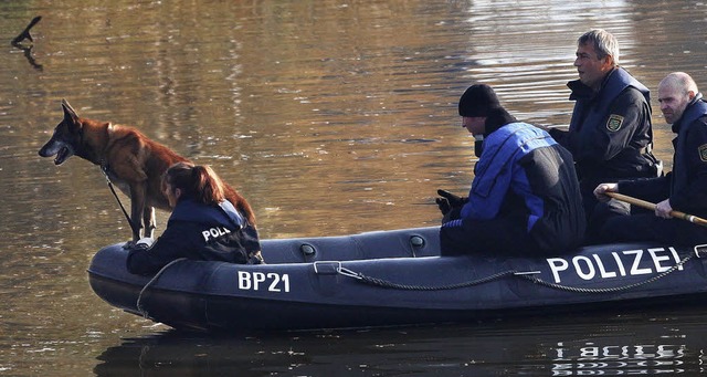 Auf der Elster suchen Polizisten mit e...Sprhund nach weiteren Leichenteilen.   | Foto: dpa