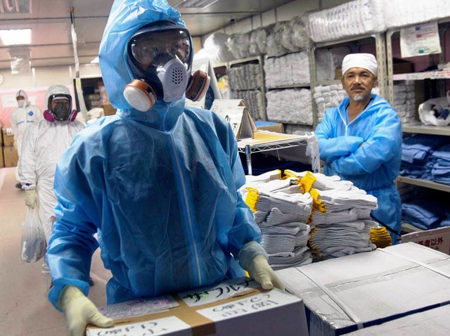 Mit Maske und Schutzanzug: Die Arbeite...dauern an. Die Strahlenbelastung auch.  | Foto: AFP