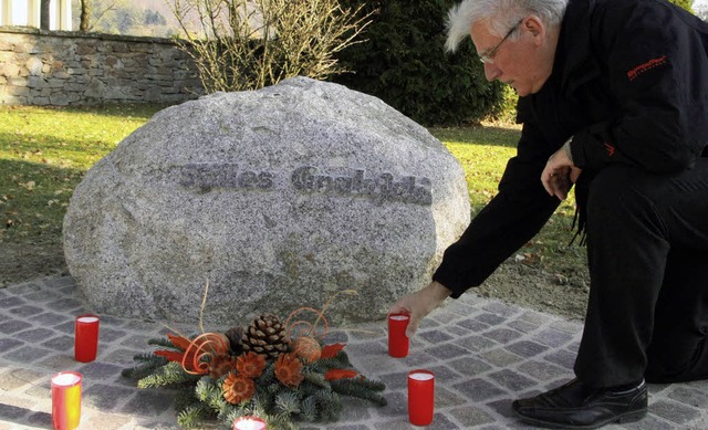 Fred Thelen platziert eine Kerze am St...berfeld auf dem  Wallbacher Friedhof.   | Foto: Max Schuler