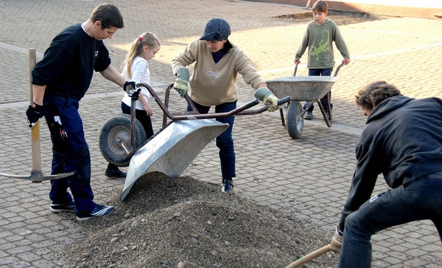 Schler und Eltern beim Vorbereiten einer Baumeinfassung auf dem Schulhof.  | Foto: Roland Vitt