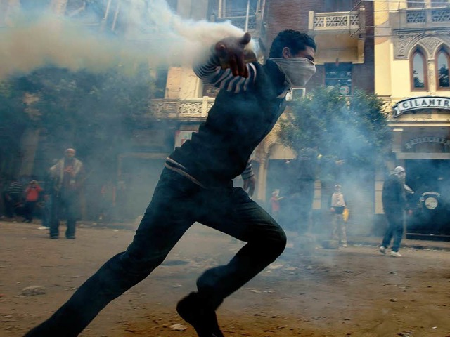 Ein Demonstrant in Kairo  versucht, ei...er in Richtung Polizei zurckzuwerfen.  | Foto: afp