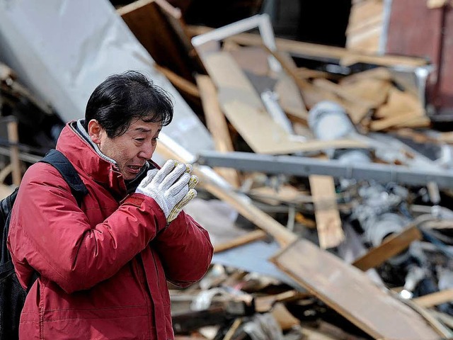 Nach dem Erdbeben in Japan stehen die Menschen erschttert vor den Trmmern.  | Foto: AFP