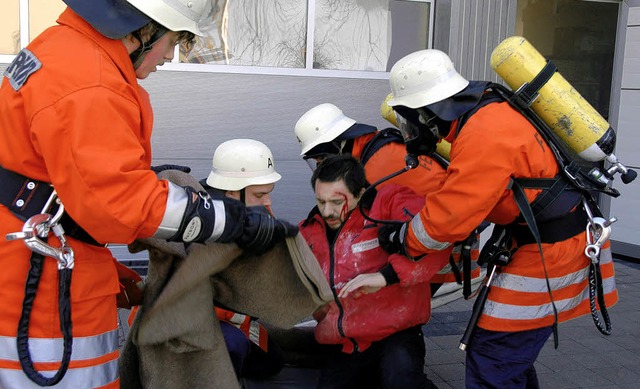 Ein &#8222;Verletzter&#8220; wird von ... ins Freie und in Sicherheit gebracht.  | Foto: Roland Vitt