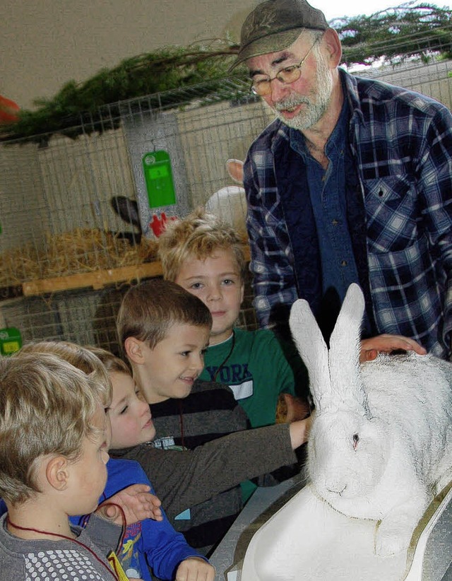 Willi Hartenbach zeigt Kindern einen Deutschen Riesen.   | Foto: Umiger