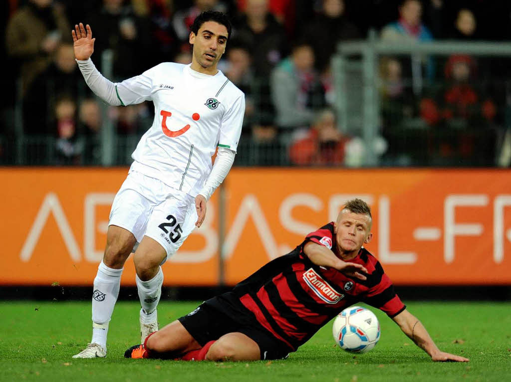 Jonathan Schmied (SC Freiburg) geht im Spiel gegen Mohammed Abdellaoue aus Hannover zu Boden.