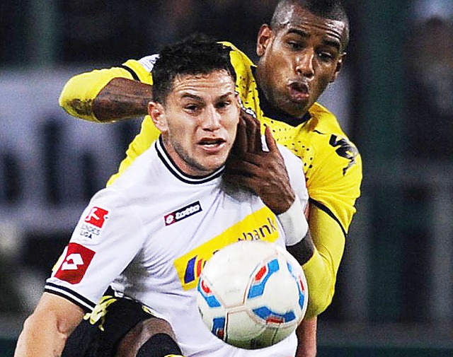 Dynamische Duell: der Gladbacher Bobadilla (vorn) gegen den Dortmunder Santana.  | Foto: afp