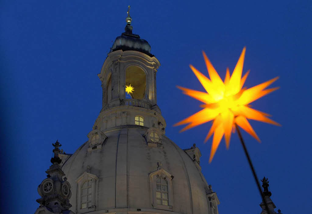 Ein Weihnachtsstern  vor der Kuppel der Frauenkirche in Dresden.
