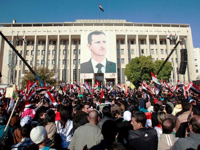 Anhnger Baschar al-Assads versammeln ...tstadt Damaskus vor seinem Konterfei.   | Foto: DPA